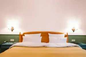 Una camera d'albergo dell'HENRI Hotel Garmisch-Partenkirchen con un letto davanti a una parete verde e bianca.