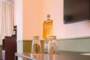 Una bottiglia e dei bicchieri su un tavolo.