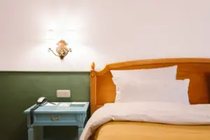 La camera d'albergo Chambre dell'HENRI Hotel Garmisch-Partenkirchen con un letto davanti a una parete verde e bianca.