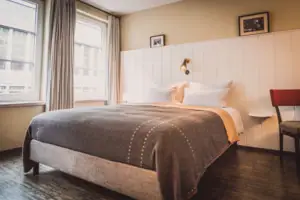 Letto con lampada e finestra in un'elegante camera d'albergo.